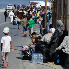 Refugiados y migrantes del destruido campamento de Moria hacen fila para ingresar a un nuevo campamento temporal durante una operación policial, en la isla de Lesbos. REUTERS / Elias Marcou