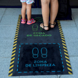 Una madre y su hija se limpian los zapatos durante la reapertura de una escuela infantil en Madrid. EFE/ Rodrigo Jiménez/Archivo