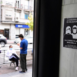 Unos vecinos conversan en la Avenida de la Albufera en el distrito del Puente de Vallecas que será confinado este lunes / EFE