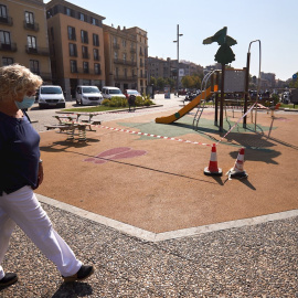 Una mujer pasea por una plaza de Girona, este miércoles en que el ayuntamiento de la ciudad ha tomado nuevas medidas para frenar la covid-19, cerrando parques infantiles. /EFE