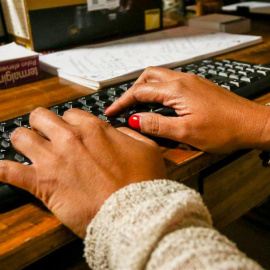 Unas manos de mujer escriben en el teclado de un ordenador, sobre una mesa de madera. - Ricardo Rubio - Europa Press - Archivo