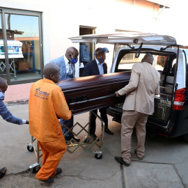 Operarios de una funeraria transportan un féretro en Sudáfrica. | REUTERS