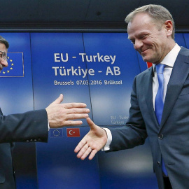 El primer ministro turco, Ahmet Davutoglu, estrecha la mano del presidente del Consejo Europeo, Donald Tusk.