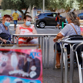 Una vecinas descansan en la terraza de un bar del barrio de la Pastoreta de Reus (Tarragona) donde este lunes se han reanudado los cribados masivos de PCR a los vecinos. /EFE