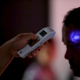 Trabajadores del Ministerio de Salud revisan la temperatura de pasajeros provenientes de un vuelo de España el 2 de marzo, en el aeropuerto La Aurora de Ciudad de Guatemala | EFE