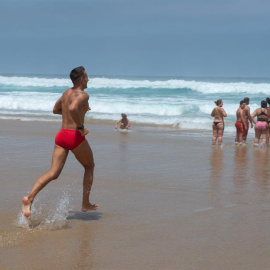 Varias personas disfrutan del baño en la orilla de la playa de Cofete, en el municipio de Pájara, en la isla de Fuerteventura. EFE/ Carlos de Saá