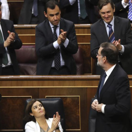 El presidente del Gobierno, Mariano Rajoy (d, abajo), es aplaudido por la bancada popular tras la votación en el pleno del Congreso de los Diputados. /EFE