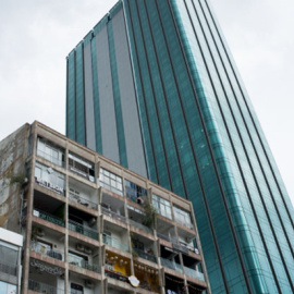 Un viejo edificio hace frente a un rascacielos moderno en el distrito céntrico 1 en Ho Chi Minh. Los dos edificios están en la primera y única calle peatonal de Vietnam. La mitad de los pisos en el edificio antiguo han sido convertidos en cafeterías.