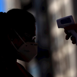 Un sanitario toma la temperatura a una mujer. EFE/Mariscal