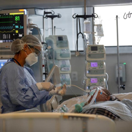 Una médica observa a un paciente en la Unidad de Cuidados de Intensivos / EFE /Sebastiao Moreira