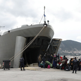 Un grupo de refugiados embarca en el buque militar enviado por el Gobierno griego a la isla de Lesbos.- REUTERS