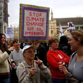 Una mujer sujeta una pancarta contra en protesta contra el cambio climático y las emisiones de CO2. REUTERS/Henry Nicholls