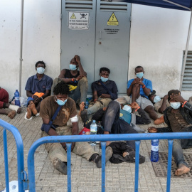 Las personas migrantes que acaban de sortear la valla de Melilla esperan a las afueras de la Plaza de Toros./ José Palazón