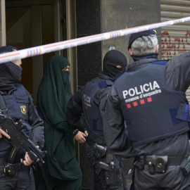 Agentes de los Mossos d'Esquadra detienen a una joven en el marco de una operación contra el terrorismo yihadista. ALEJANDRO GARCIA (EFE)