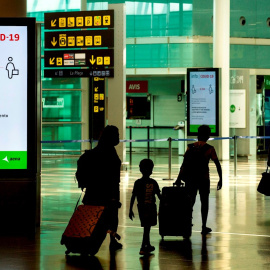 Viajeros con máscaras sanitarias caminan por la Terminal 1 del aeropuerto Josep Tarradelles - El Prat, en Barcelona. EFE/ Enric Fontcuberta