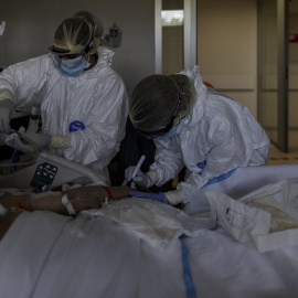 Personal sanitario totalmente protegido atiende a un paciente ingresado en la Unidad de Cuidados Intensivos del Hospital Infanta Sofía en San Sebastián de los Reyes (Madrid). Eduardo Parra / Europa Press