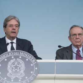El primero ministro italiano, Paolo Gentiloni (i), con el ministro de Economía, Pier Carlo Padoan (d), en la comparecencia ante los medios en el Palacio Chigi, sede del Consejo de Ministros, para informar sobre la liquidacion de los banco Veneto Banca y 