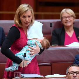 La senadora australiana Larissa Waters amamanta a su bebé mientras interviene en el parlamento. REUTERS