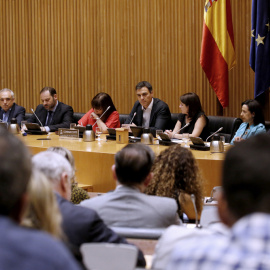 El secretario general del PSOE, Pedro Sánchez, durante su intervención por primera vez ante el grupo parlamentario socialista, con su equipo: la presidenta del partido, Cristina Narbona (4i), Margarita Robles (3d) y el senador burgalés Ander Gil (2d), 