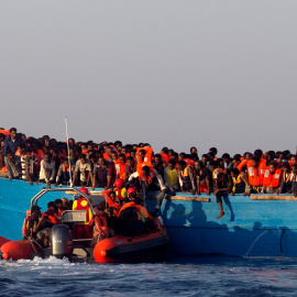 Un barco de rescate de la ONG española Proactiva se acerca a una patera de madera abarrotada de inmigrantes procedentes de Eritrea, frente a la costa de Libia en el Mar Mediterráneo. REUTERS/Giorgos Moutafis