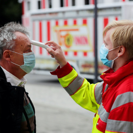 Personal de salud mide la temperatura a un hombre este sábado en Berlín. REUTERS/Hannibal Hanschke