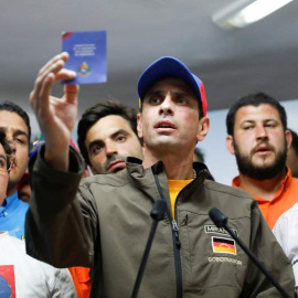 Henrique Capriles sostiene un ejemplar de la Constitución Bolivariana de Venezuela durante un acto de la oposición. | REUTERS