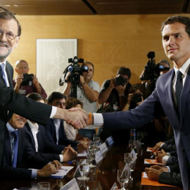 El jefe del Gobierno, Mariano Rajoy,iz., y el líder de Ciudadanos, Albert Rivera, se estrechan la mano durante la reunión de sus respectivas delegaciones en la que van a certificar el acuerdo de investidura-.EFE/Sergio Barrenechea