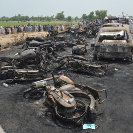 Coches y motocicletas carbonizados en la carretera de Pakistán donde un camión cisterna ha tenido un accidente y ha estallado, provocando más de 120 muertos. EFE / EPA / FAISAL KAREEM