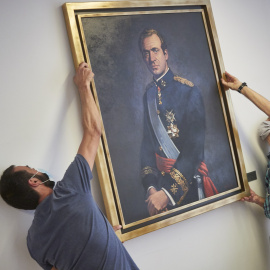 Dos operarios retiran del retrato del rey emérito Juan Carlos I de la Sala de Gobierno del Legislativo foral del Parlamento de Navarra. Eduardo Sanz / Europa Press / Archivo