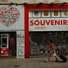 Una mujer con mascarilla pasa por delante de una tienda de souvenirs cerrada en el centro de Madrid. REUTERS/Susana Vera