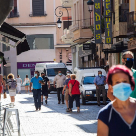 Varias personas protegidas con mascarilla caminan este lunes por la calle más comercial de Aranda. La zona básica de salud de Aranda de Duero (Burgos) presenta este lunes 49 casos de Covid-19. EFE/ Pacosantamaria