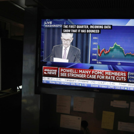 Un monitor de TV en el patio de negociación de la Bolsa de Nueva York en Wall Street muestra la rueda de prensa del presidente de la Reserva Federal, Jerome Powell, tras la reunión en la que se han mantenido sin tocar los tipos de interés. REUTERS/Luca