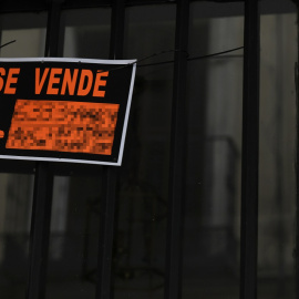 Cartel colgado en un edificio que avisa de una vivienda en venta. E.P./Óscar Cañas