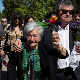 La lucha de una vida. Ascensión levanta unas flores con los colores republicanos junto a su hijo.- REUTERS