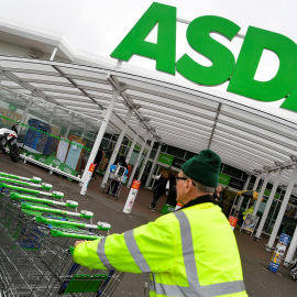 Un trabajador traslada una fila de carritos de la compra en un establecimiento de la cadena de supermercados británica Asda, en Londres. REUTERS/Toby Melville