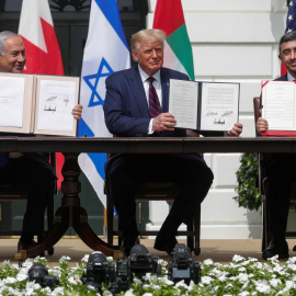 El primer ministro de Israel, Benjamin Netanyahu, el presidente de los Estados Unidos, Donald Trump, y el ministro de Relaciones Exteriores de los Emiratos Árabes Unidos (EAU), Abdullah bin Zayed, muestran sus copias de los acuerdos firmados mientras par