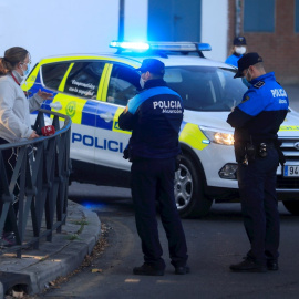 Una patrulla de la policía local conversa con una vecina este lunes, en la primera jornada de restricciones aplicadas a las áreas sanitarias de Miguel Servet y Doctor Trueta de la localidad madrileña de Alcorcón. EFE/Fernando Alvarado