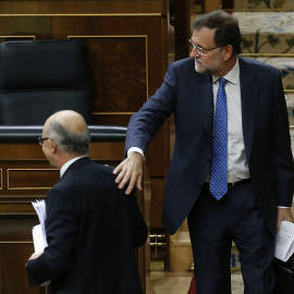 El presidente del Gobierno, Mariano Rajoy, felicita al ministro de Hacienda, Cristóbal Montoro, tras la intervención de éste ante el pleno del Congreso para defender los Presupuestos Generales del Estado para 2016. EFE/Paco Campos
