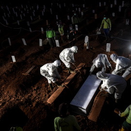 Trabajadores con trajes protectores entierran a una víctima de la enfermedad por coronavirus en Indonesia. Antara Foto / Muhammad Adimaja / REUTERS