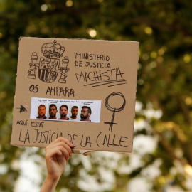 La imagen de los cinco miembros de la llamada Manada, en una pancarta sostenida por una manifestante en una protesta en Sevilla en junio de 2018. REUTERS/Marcelo del Pozo