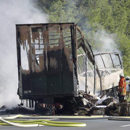 Los bomberos trabajan junto a los restos calcinados de un autobús en la carretera A9 en la zona de Núremberg cercana a Münchberg (Alemania). | STEPHAN FRICKE (EFE)