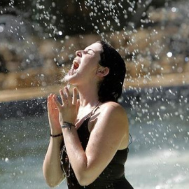 Una joven bebe de una fuente en plena ola de calor. EFE/Archivo