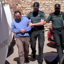 El hijo de la mujer hallada muerta en el domicilio familiar en la localidad de Pozondón, acompañado por agentes de la Guardia Civil. EFE