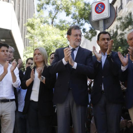 El presidente del Gobierno y del PP, Mariano Rajoy, junto a Marimar Blanco y otros dirigentes del PP en el despliegue de la pancarta en la sede del partido. | JUAN CARLOS HIDALGO (EFE)