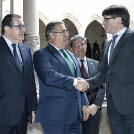 Carles Puigdemont saluda Juan Ignacio Zoido abans de l'inici de la reunió de la Junta de Seguretat de Catalunya. EFE/Andreu Dalmau