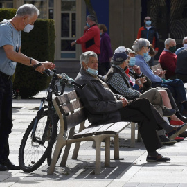 Varias personas descansan en un banco protegidos con mascarilla durante la segunda jornada en la capital leonesa por el confinamiento perimetral provocado por la Covid-19. Castilla y León ha anotado este jueves 775 positivos por PCR y de antígenos, con 