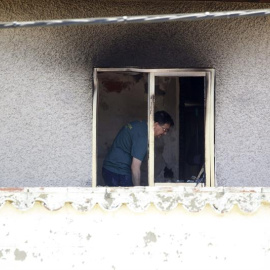 Agentes de la Guardia Civil investigan en una de las habitaciones de la residencia privada de Santa Fe, en la localidad de Cuarte de Huerva, cerca de Zaragoza, donde anoche un incendio causó la muerte a ocho ancianos y heridas a otros doce./ EFE