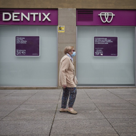 Una mujer paseas enfrente de una clínica Dentix en Pamplona. E.P./Eduardo Sanz