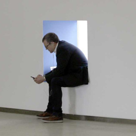 Un ejecutivo consulta su dispositivo móvil.- EFE