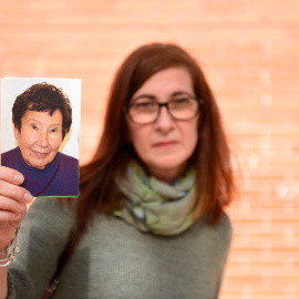 La hija de María Jesús sujetando una fotografía de su madre.